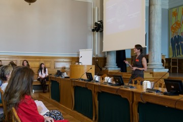 A speaker addressing the room from the side of the chamber