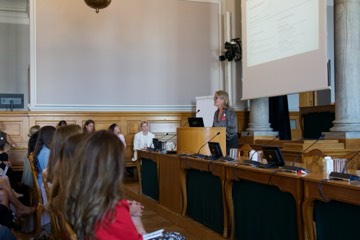A speaker addressing the room, seen from the audience