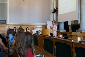 A speaker addressing the room, seen from the audience