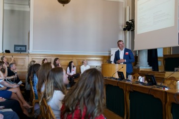 A speaker addressing the room, seen from the audience