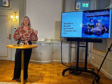 A speaker beside the slide “Health is deeply personal. Systems are not.”