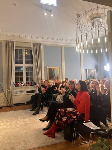 The audience applauding under the chandelier